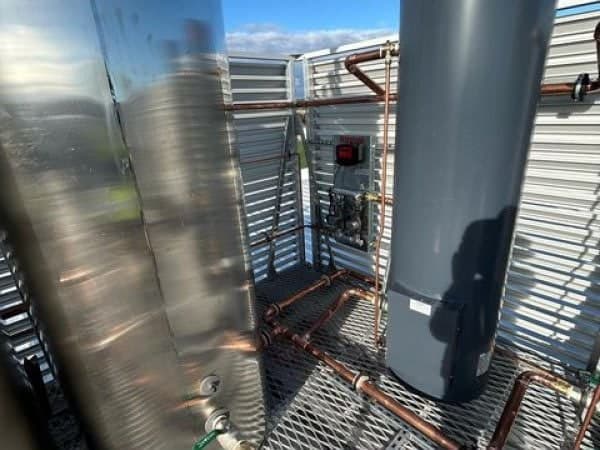 Gas hot water units and copper gas pipework in a rooftop plant area