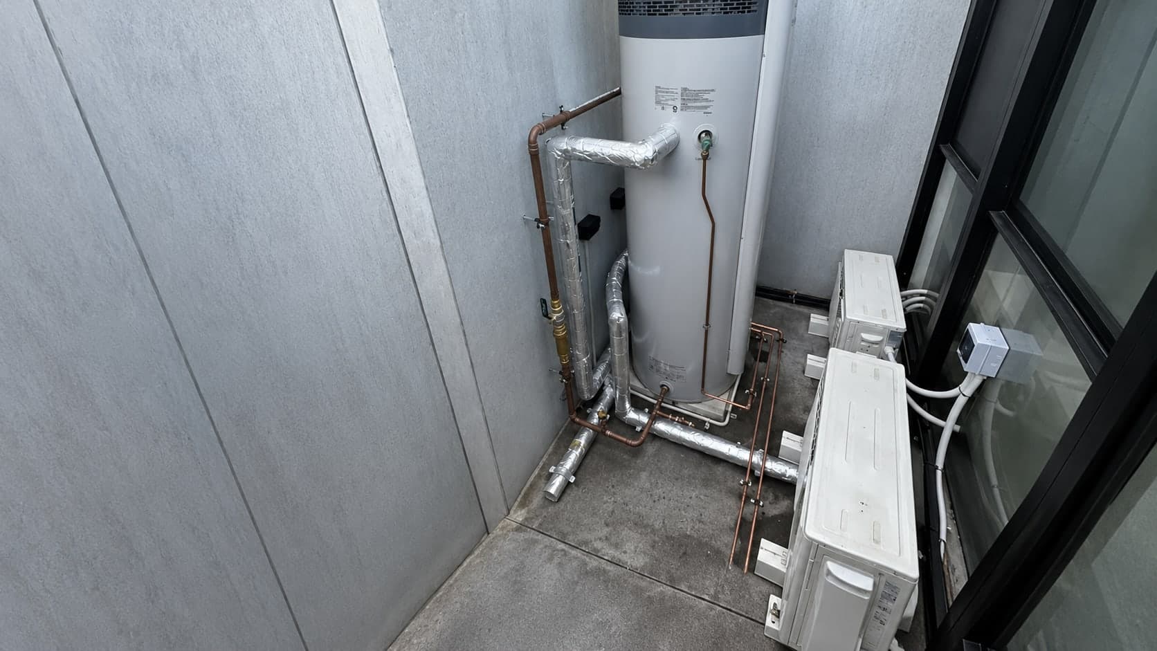 Hot water system, pipework and air conditioning units in a service corridor