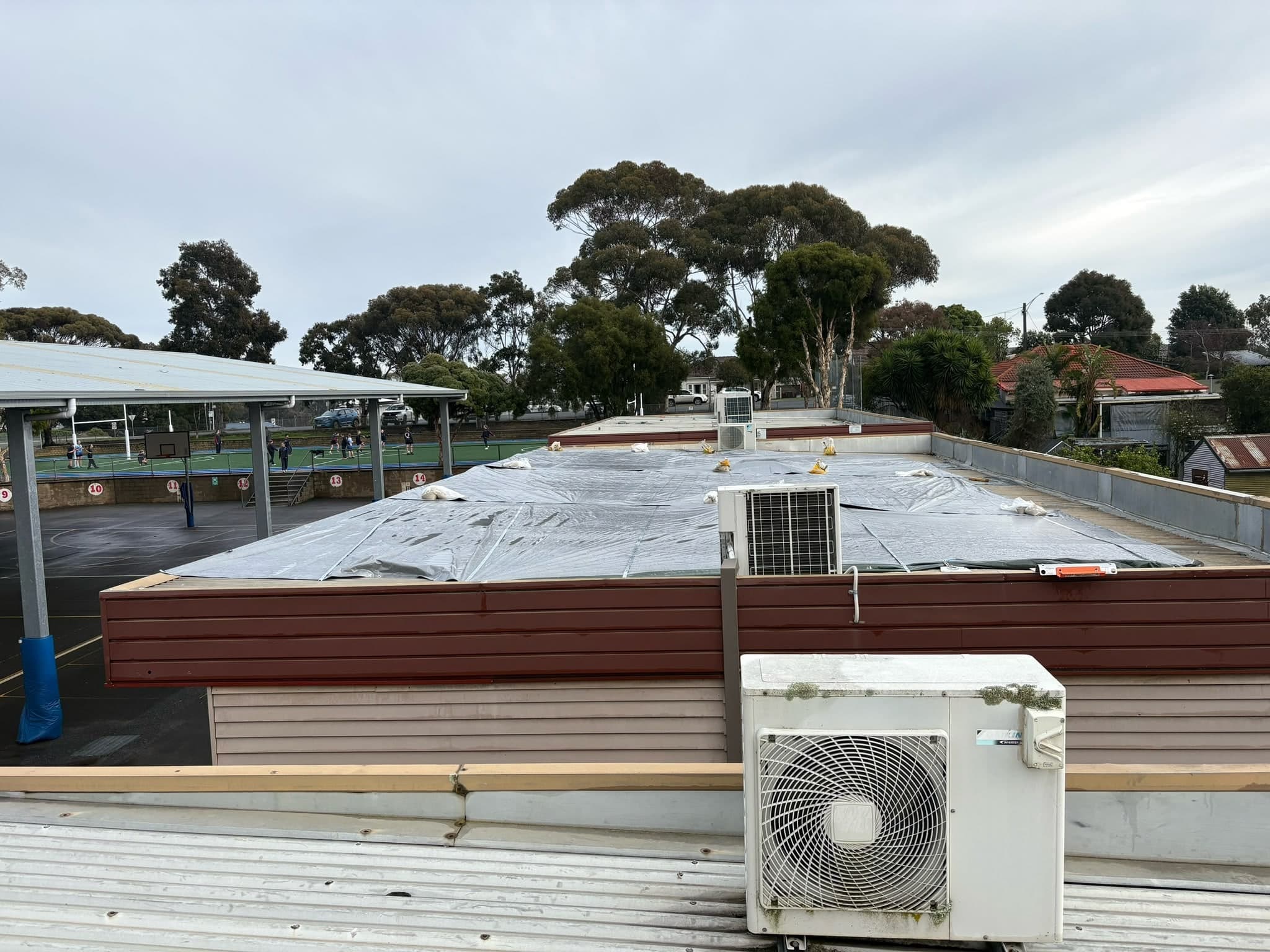 Flat roof fully tarped after storm damage, ready for insurance repairs