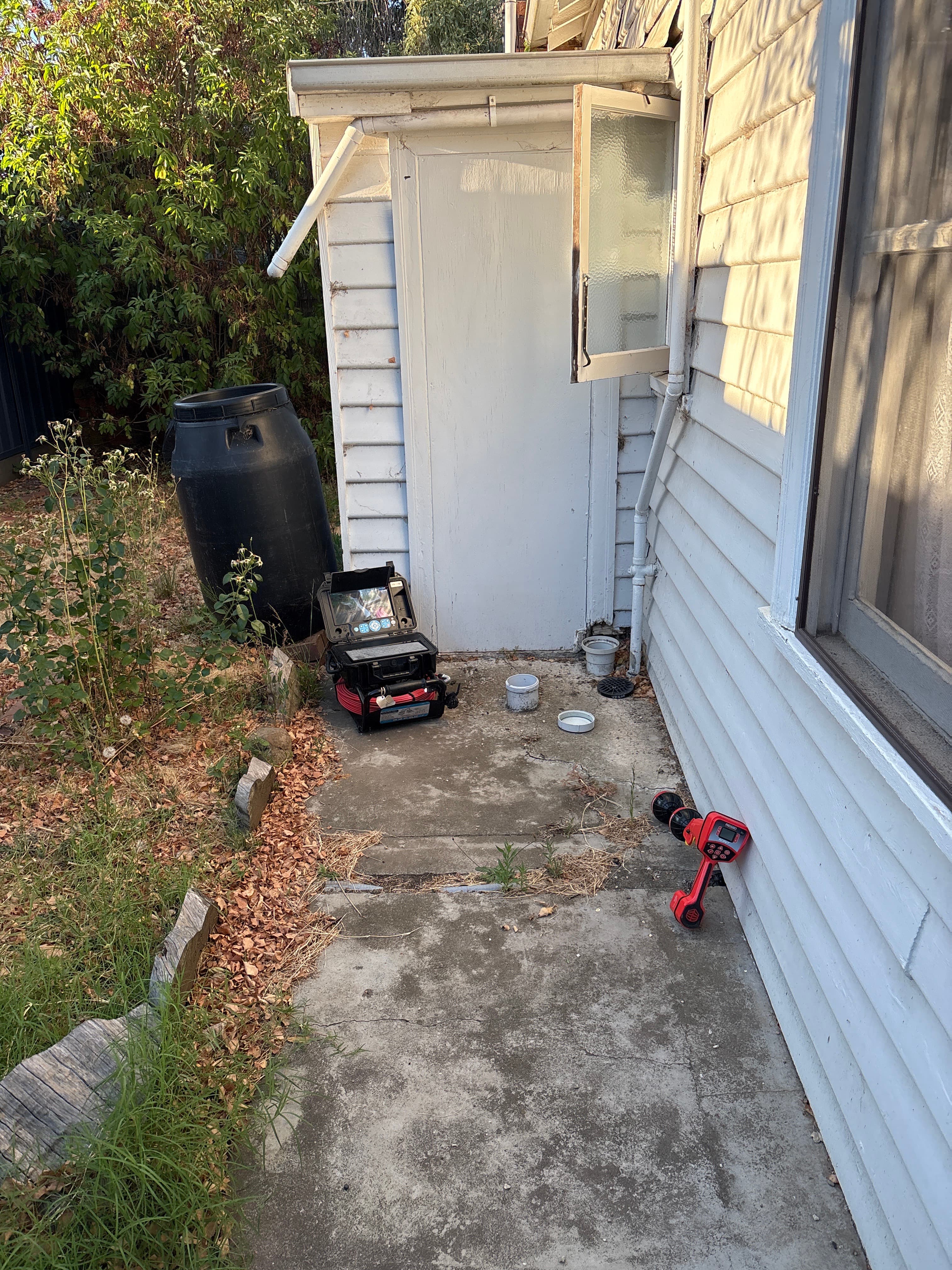 CCTV drain camera and locating equipment set up beside a home